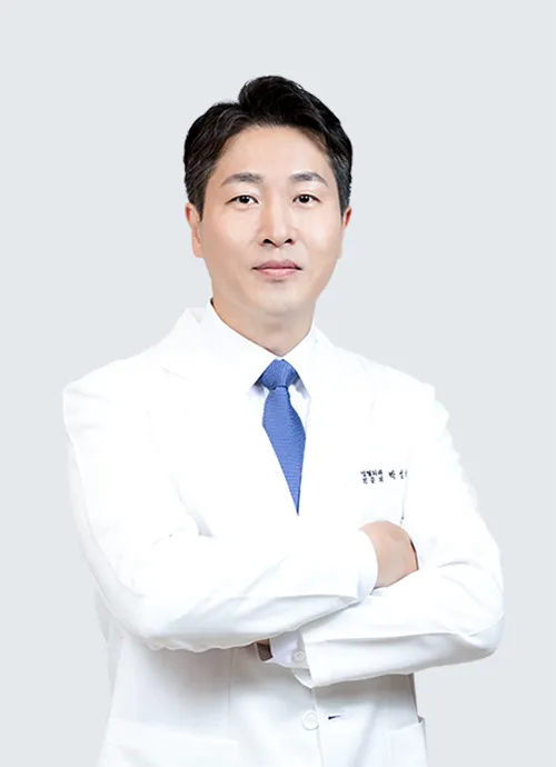 Dr. Park Seong-uk, plastic surgeon at UcanB, in a white coat and blue tie