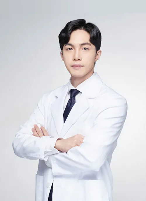 Dr. Song Yu-seong, plastic surgeon at UcanB, in a white coat with arms crossed