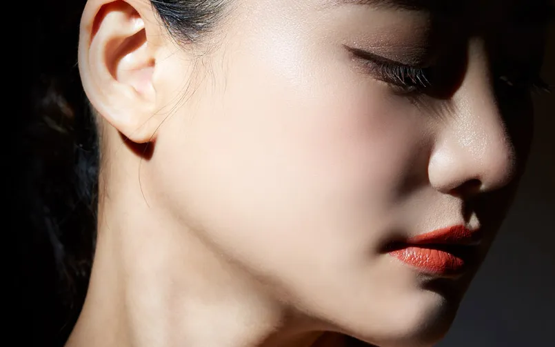 Side-lit profile of a model showing a smooth jaw and cheek line