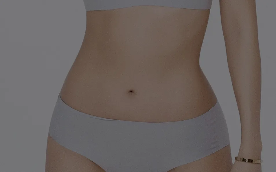 Slim waist and abdomen of a model in light underwear